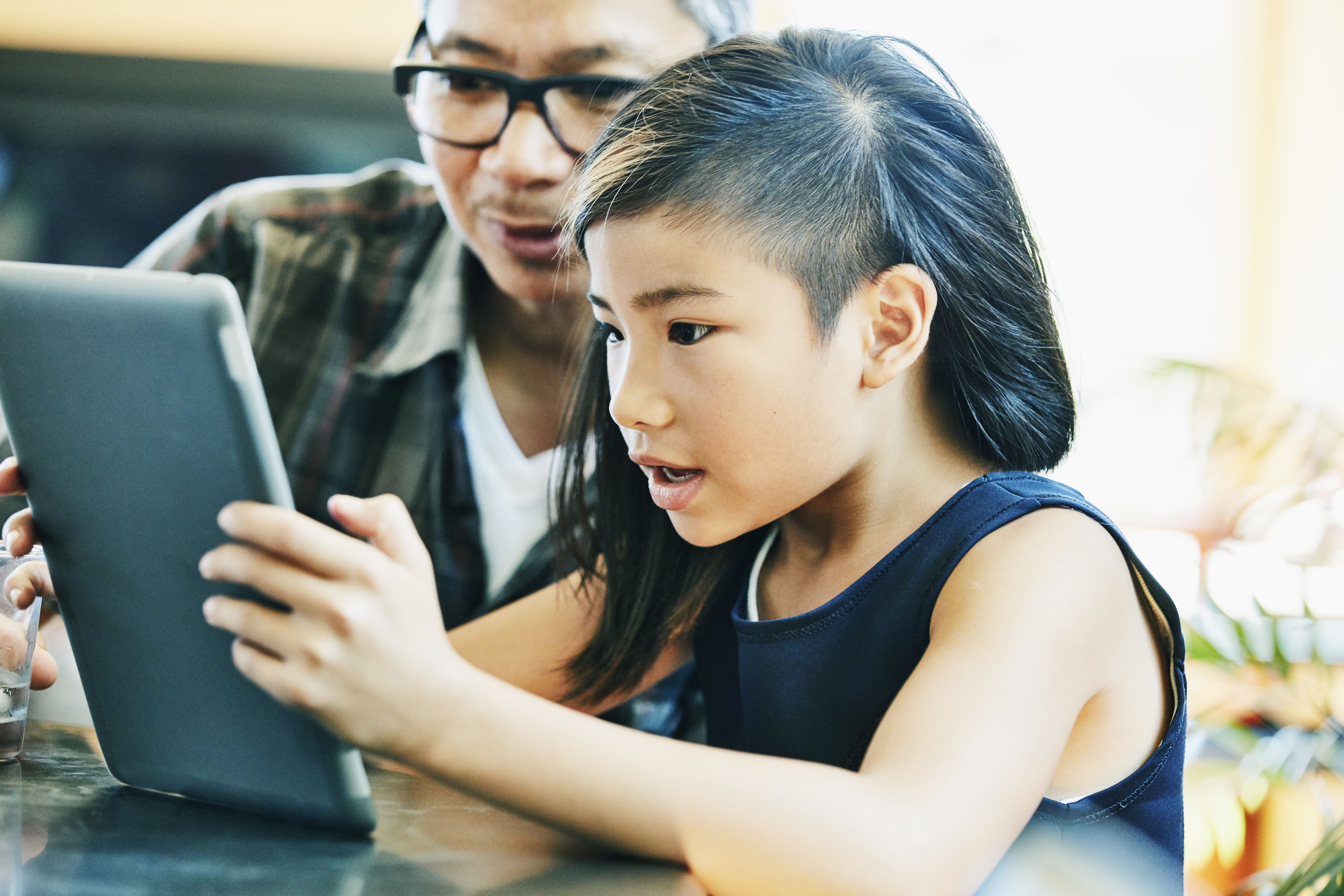 young girl using tablet with mother